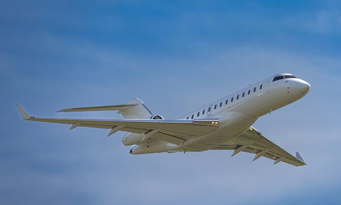 Leidos' white Bombardier 6500 jet aircraft pictured in the air