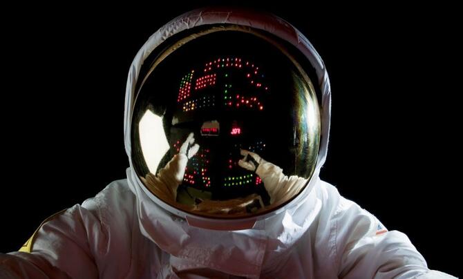 An astronaut in space making adjustments to a control panel