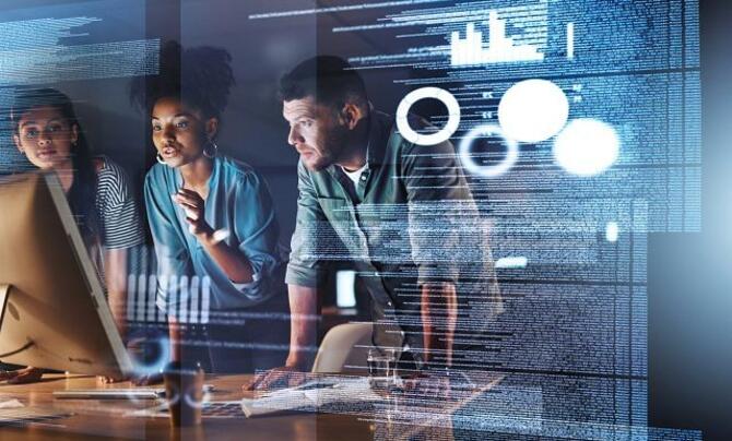 Three workers discussing something around a desk