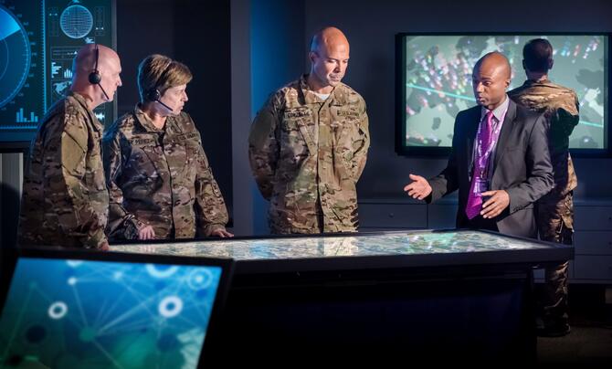 People in military uniforms standing around a table