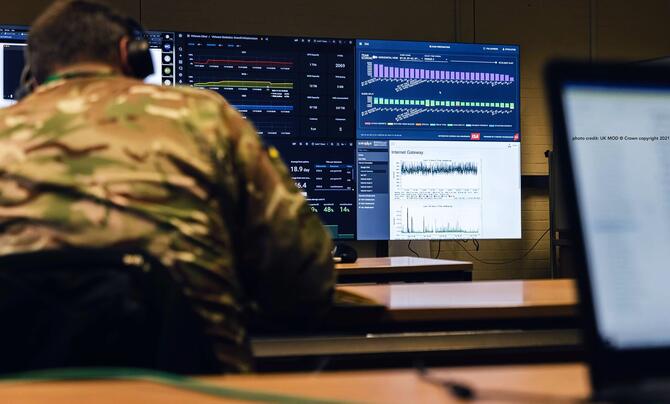 A man in a military uniform working at a computer