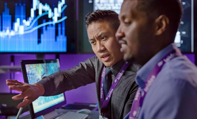 Two men talking at a computer