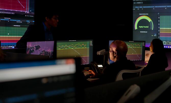 A man sitting in front of multiple screens
