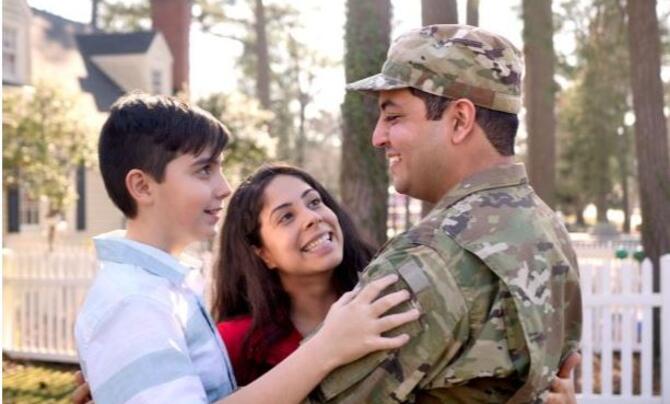 A military family holding each other