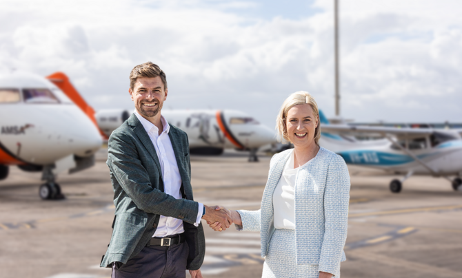 man and woman shaking hands on airport tarmac