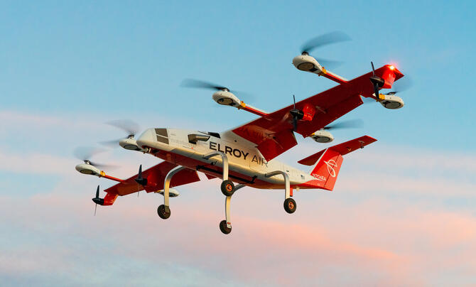 A white and orange hybrid-electric vertical take-off and landing cargo aircraft called Chaparral.