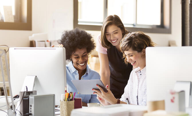 three women looking at tablet