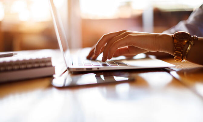 Woman typing on laptop at a cafe