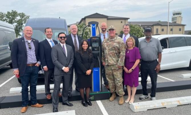 group of people in front of electric vehicle charging station