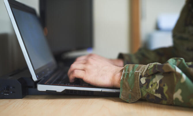 a soldier using a laptop