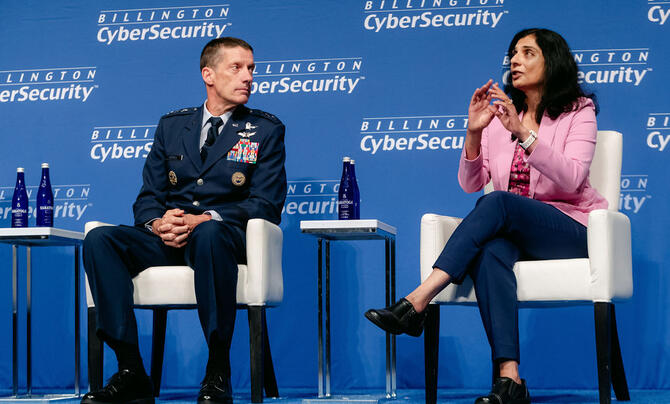 two people talking seated on a stage