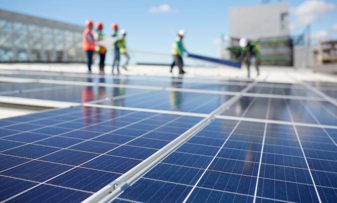 solar panels with utility workers in background