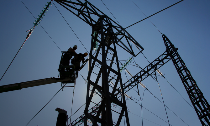 two utility workers fixing power lines