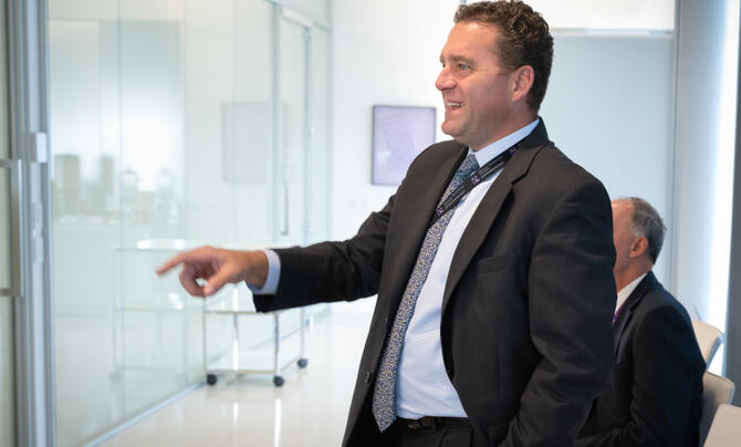 candid photo of man pointing at white board