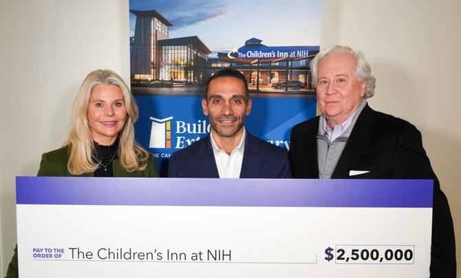 three people holding a check