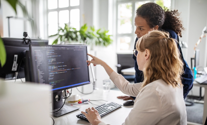 two women looking at computer screen
