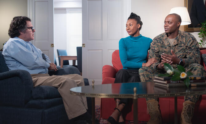A service member and spouse sit in a room with a social worker.
