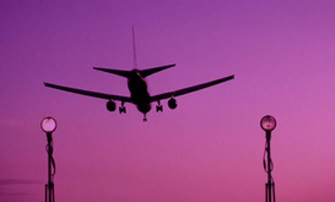 Plane landing with purple sunset