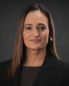 A woman smiling at the camera wearing a black blazer