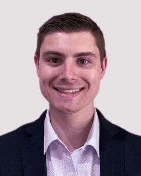 A man in a suit smiling at the camera