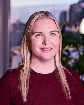 A woman in a red shirt smiling at the camera