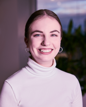 A woman in a girl turtleneck smiling at the camera
