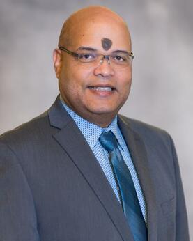 Dr. Braulio Cabral headshot picture on a gray background