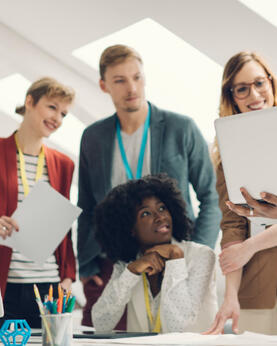 Group of employees around a laptop
