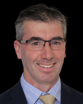 Man smiling at the camera wearing glasses