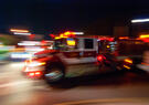 Stylized motion-blurred image of a fire truck en route.