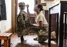 Daughter wearing U.S. soldier mother's uniform at home