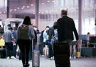 Passengers at an airport walking through the concourse