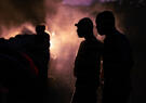 Dark image with silhouettes of US Army ROTC cadets with the backlight obscured by fog