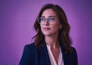 Woman wearing glasses against purple background