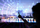 Woman in silhouette touching a transparent screen with city lights in the background