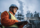 https://www.gettyimages.com/detail/photo/serious-handsome-engineer-using-a-laptop-while-royalty-free-image/1310818458?searchscope=image%2Cfilm&adppopup=true An engineer in high visibility safety gear, using a laptop outside a power plant