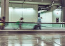 people walking through moving walkway