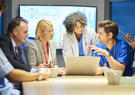 photo showing team of doctors, nurses and administrators discussing care