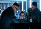 Military and intelligence personnel looking at computer