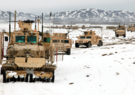 Humvees in a caravan driving through snow