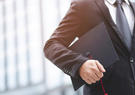 man holding mortarboard by his side