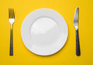 Fork, plate, and knife set with a yellow background