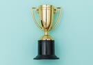 A gold trophy on a light green background
