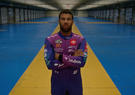NASCAR Driver Bubba Wallace in Leidos racing suit standing in an empty garage with arms crossed