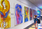 A young traveler takes a moment to appreciate the beauty of a painting inside an airport terminal