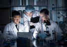 Scientists working in a lab huddled around a computer