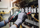 Worker with PPE working on an electrical panel