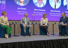 A group of people sitting in a panel on a stage