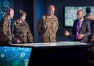 People in military uniforms standing around a table