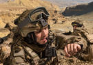 Soldier crouching and looking at his watch